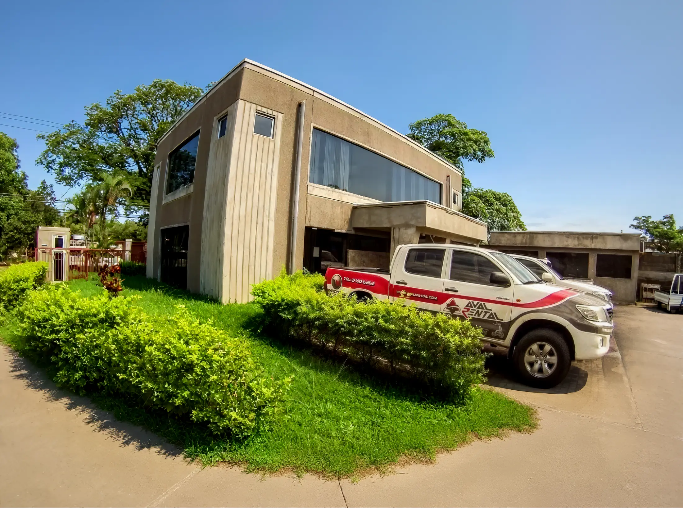 Sede de Aval Rental en Villa Bonita de Alajuela con vehículo rotulado de la empresa